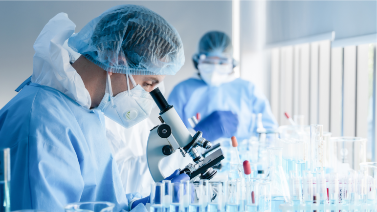 Scientist looking through microscope at samples in laboratory